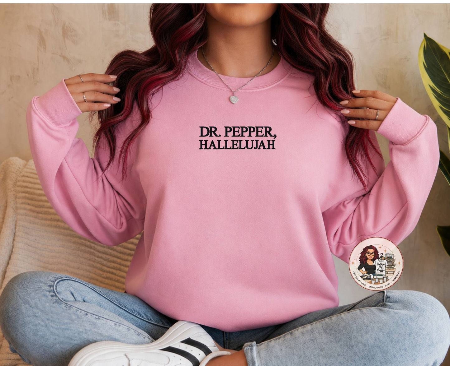 Person wearing a pink sweatshirt with 'DR. PEPPER, HALLELUJAH' text, sitting on a couch.