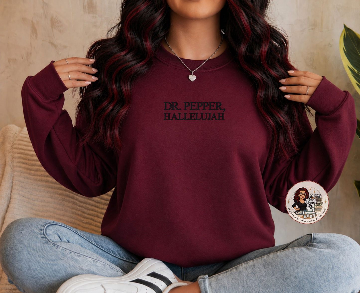 Person wearing a maroon sweatshirt with 'DR. PEPPER, HALLELUJAH' text, sitting on a beige couch.